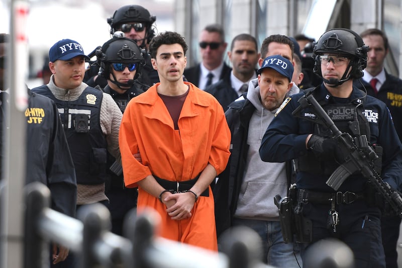 Luigi Mangione, being escorted by police, in New York on December 19 (Pamela Smith/AP)