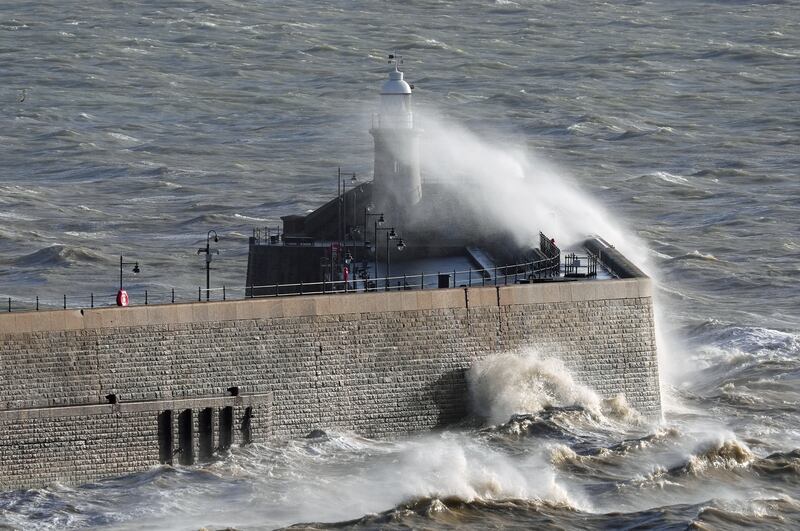 Waves crash over the harbour wall in Folkestone, Kent, on Monday