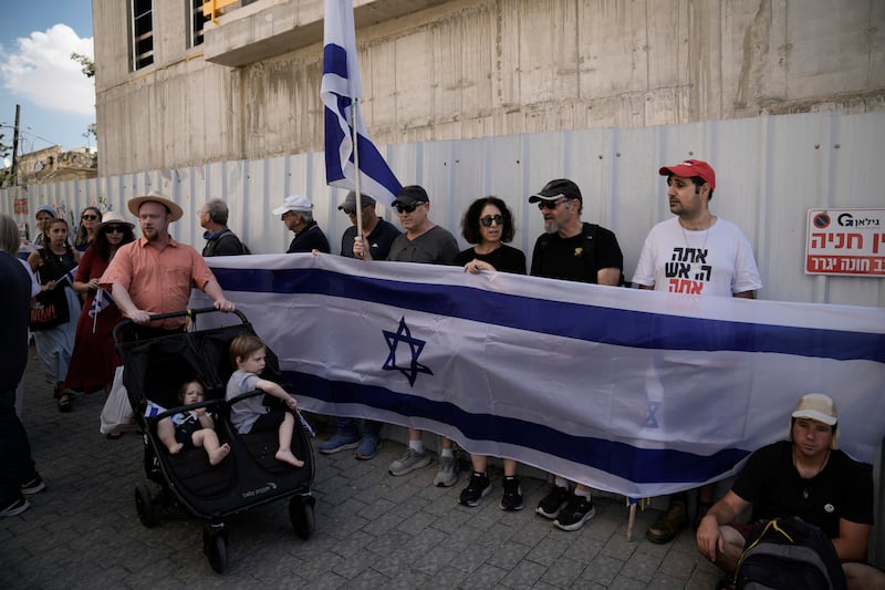 Mourners wave Israeli flags as they accompany the family of Israeli-American hostage Hersh Goldberg-Polin, who was killed in Hamas captivity in the Gaza Strip, on their way to his funeral in Jerusalem (Leo Correa/AP)