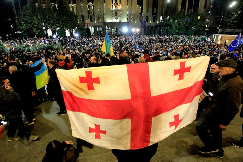 Protesters hold a Georgian flag during the opposition in Tbilisi, Georgia, on Monday (Shakh Aivazov/AP)