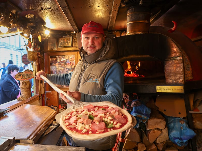 Irish News Sophie Clarkes tastes the Pizza at the Belfast Christmas Market.
PICTURE COLM LENAGHAN