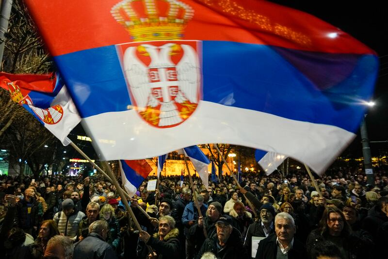 A Serbian opposition supporter waves the country’s national flag during a protest outside the electoral commission building in Belgrade (AP Photo/Darko Vojinovic)