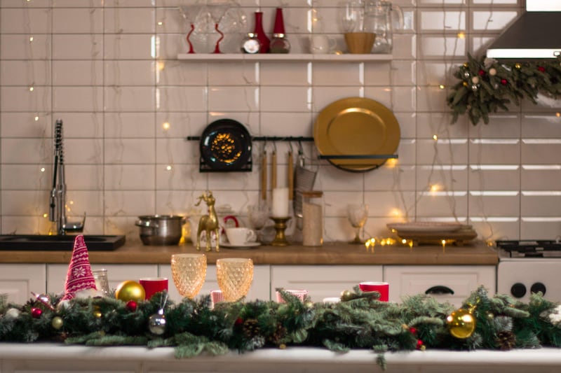 Kitchen decorated for Christmas with fairy lights, candles and pine branches for centrepiece