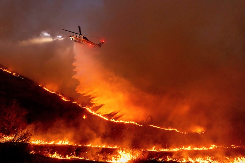 Water is dropped by helicopter on the Kenneth Fire in the West Hills section of Los Angeles (Ethan Swope/AP)