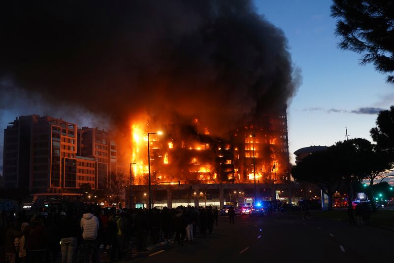 People watch the fire in Valencia from a distance (Alberto Saiz/AP)