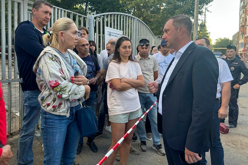 Saratov region governor Roman Busargin, right, speaks with residents of the building damaged by a drone attack on the city (Saratov region governor Roman Busargin official Telegram channel/AP)