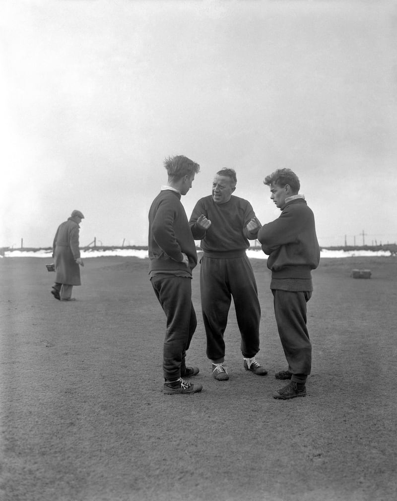 Manchester United players Bobby Charlton (l) and Ernie Taylor (r) listen to advice from the club's acting manager, Jimmy Murphy, during a training session in Blackpool for their 6th round FA Cup tie against West Bromwich Albion.