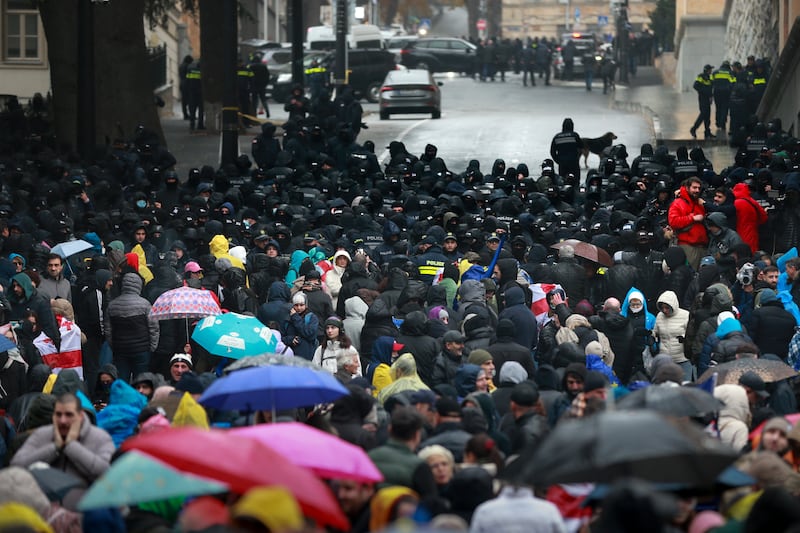 Police block protesters gathered in a street near the Parliament building in Tbilisi during a rally to demand new elections in Georgia (Zurab Tsertsvadze/AP)