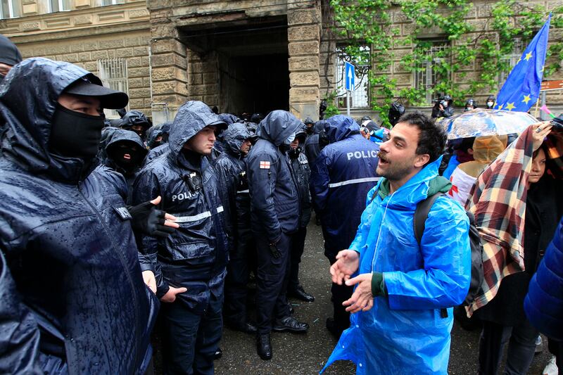 A demonstrator speaks to the police that blocked the road towards the Georgian parliament building during an opposition protest against ‘the Russian law’ (Shakh Aivazov/AP)