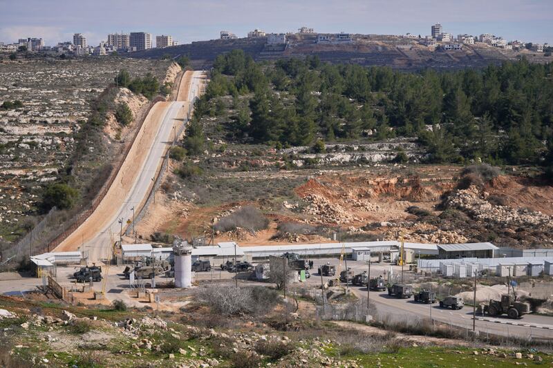 Military vehicles are lined up at the Israeli Ofer prison in the West Bank city of Beitunia awaiting the release of Palestinian prisoners (Nasser Nasser/AP)