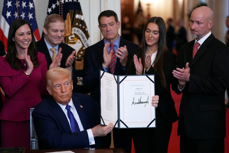 President Donald Trump holds the document after signing the Laken Riley Act during an event in the East Room of the White House (Evan Vucci/AP)