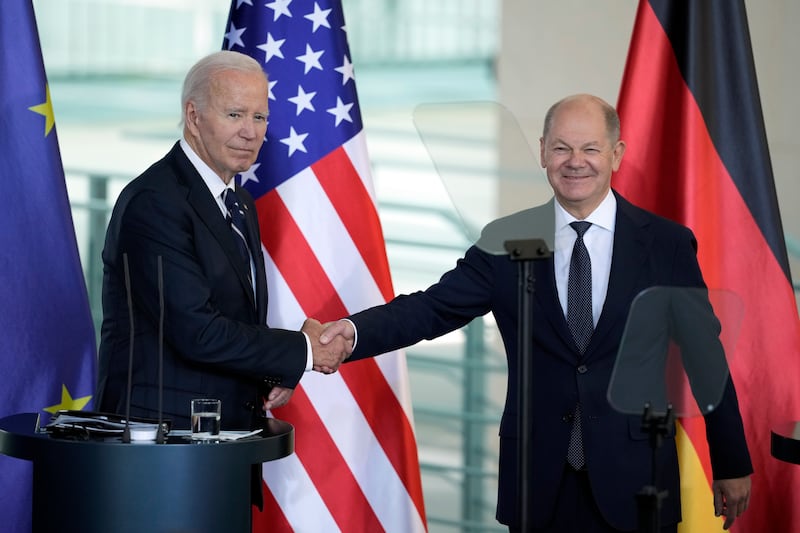 US President Joe Biden and German Chancellor Olaf Scholz shake hands after delivering joint statements to the press at the Chancellery in Berlin on Friday (Ebrahim Noroozi/AP)