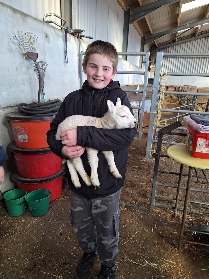 Kyle holds a baby lamb as part of his Cubs exercises.