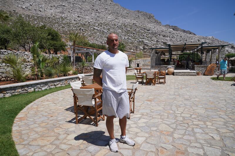 Agia Marina bar manager Ilias Tsavaris, 38, speaks to the media on Symi
