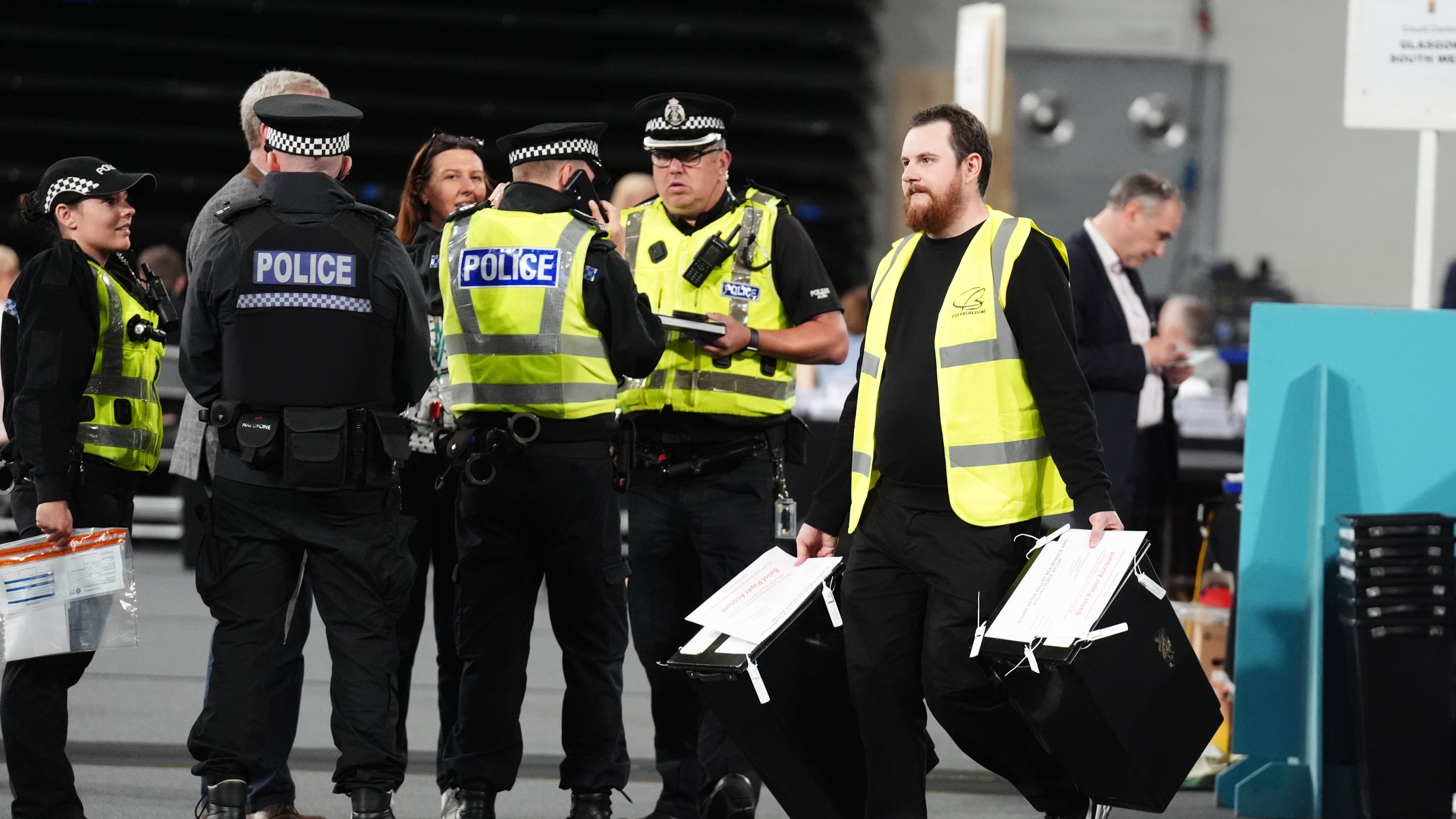 Police accompanying ballot boxes as they are carried in to the Emirates Arena in Glasgow