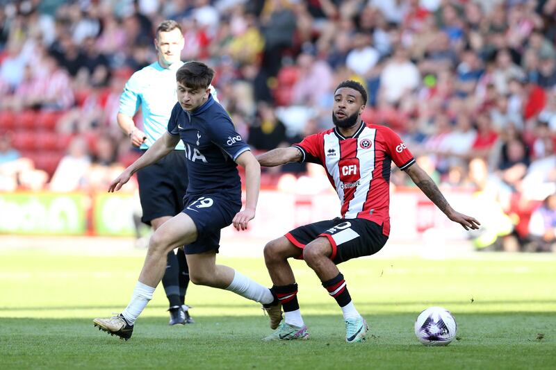 Tottenham Hotspur’s Mikey Moore (left) and Sheffield United’s Jayden Bogle battle for the ball