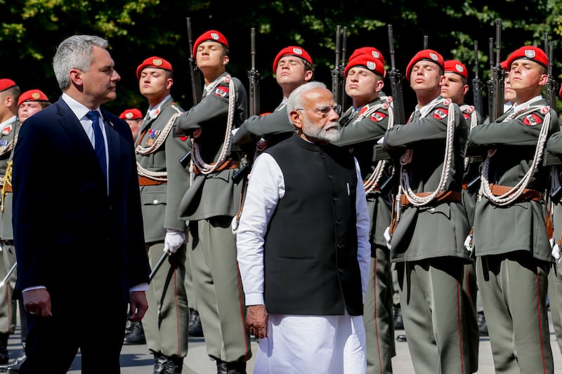 Indian Prime Minister Narendra Modi, right, is welcomed to Vienna with military honours by Austrian Chancellor Karl Nehammer (Heinz-Peter Bader/AP)