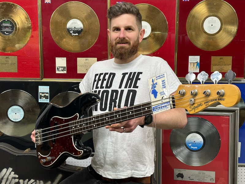 Auctioneer Luke Hobbs with Chris Cross’s Live Aid bass guitar