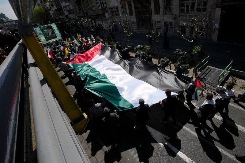 Iranians carry a huge Palestinian flag in the annual rally to mark Quds Day in Tehran (Vahid Salemi/AP)