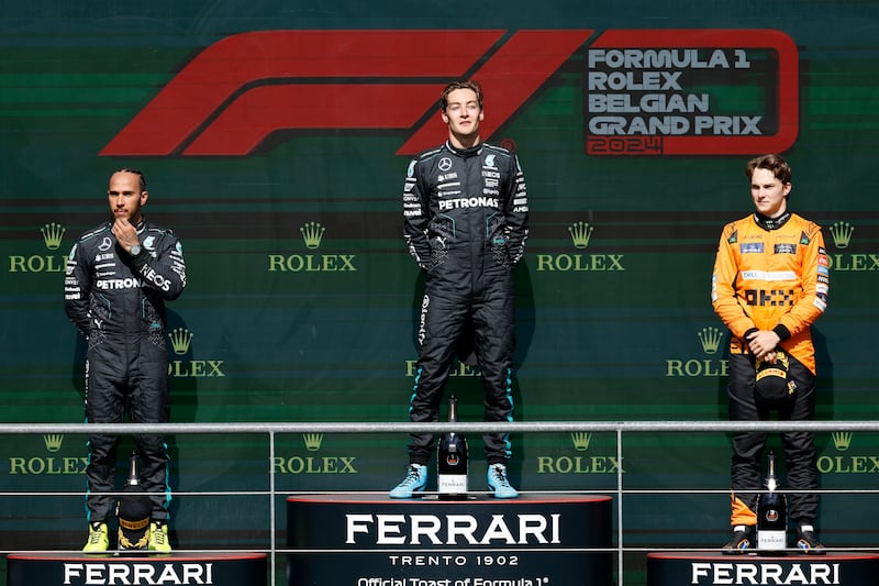 Russell (centre), Lewis Hamilton (left) and Oscar Piastri take their places on the podium (Geert Vanden Wijngaert/AP)