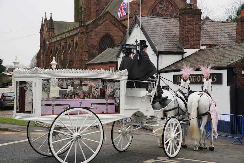 A horse-drawn carriage carrying the coffin of Brianna Ghey arriving for her funeral in Warrington, Cheshire