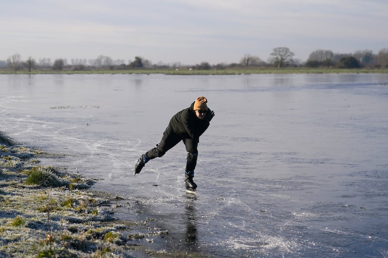 Ugo Sassi from Cambridge skates on a frozen flooded field in Upware