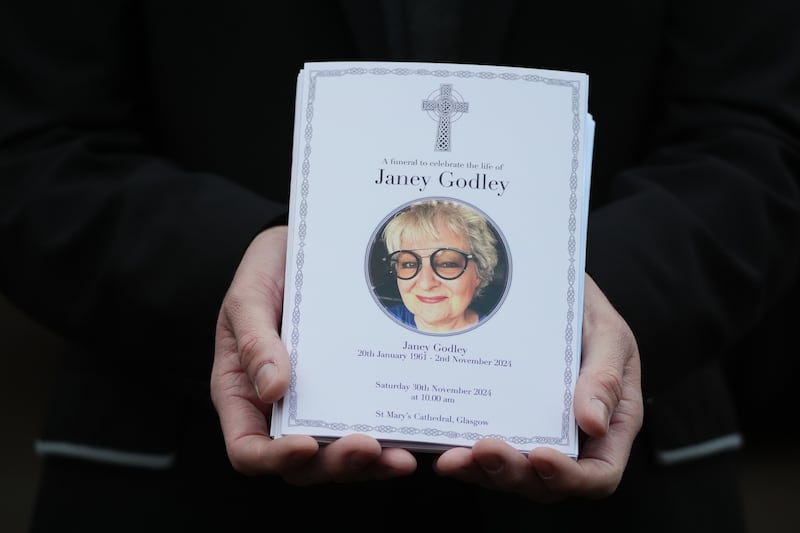 A mourner holds the order of service for the funeral of Scottish comedian Janey Godley