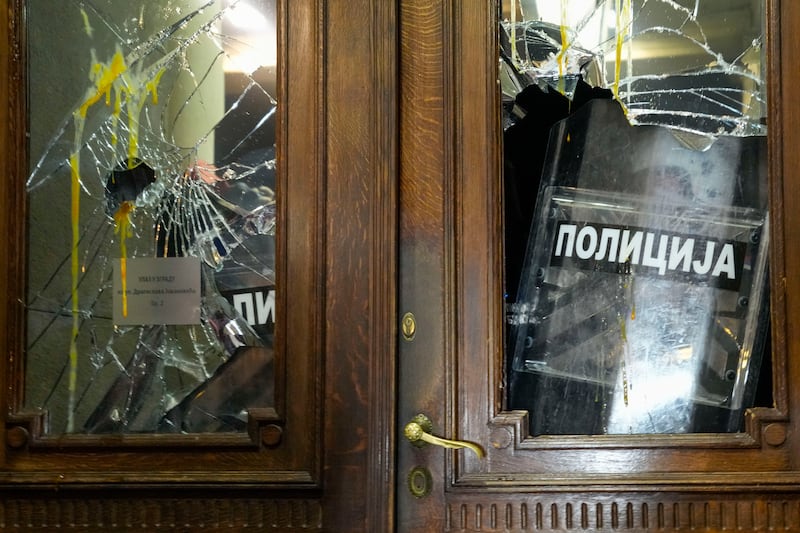 Shielded riot police barricaded themselves inside the city government building (AP Photo/Darko Vojinovic)