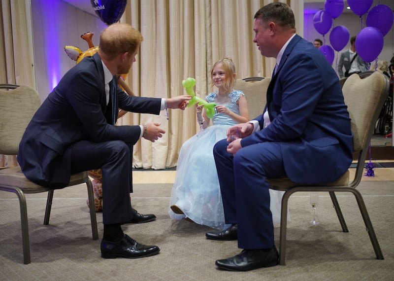 The Duke of Sussex speaks to Poppy and her father Daniel Higham during the 2023 WellChild awards