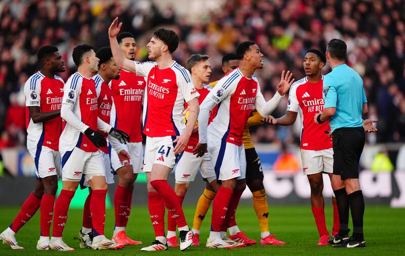 Arsenal players confront referee Michael Oliver after showing Myles Lewis-Skelly a red card