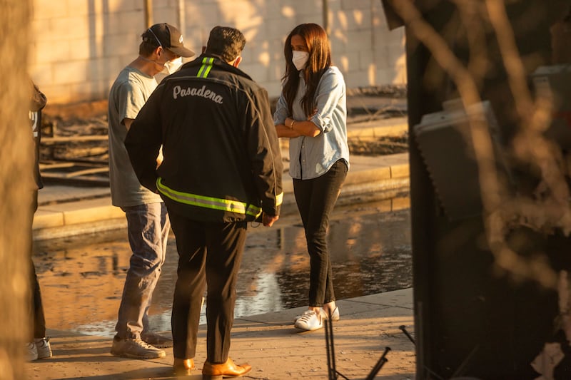 Meghan speaks to Pasadena mayor Victor Gordo, centre, and Doug Goodwin, whose home was destroyed by fire (Ethan Swope/AP)