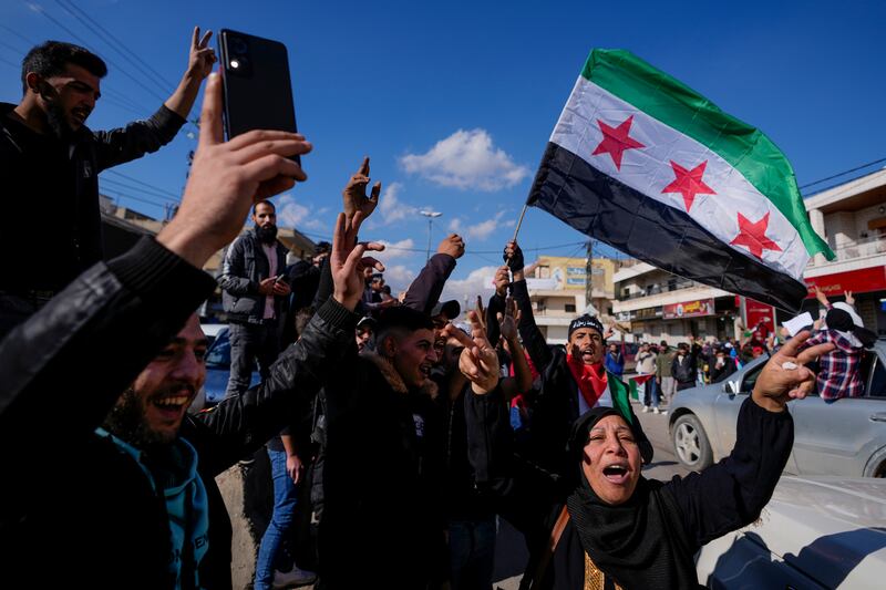 Syrians celebrate the fall of Syrian President Bashar Assad’s government in the town of Bar Elias, Lebanon, near the border with Syria (Hassan Ammar/AP)