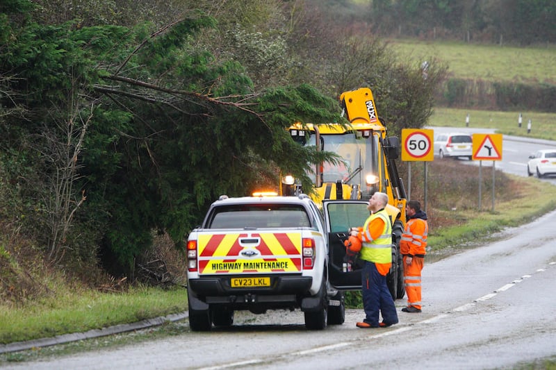 A fallen tree is cleared away after heavy winds near in Bridgend, Wales