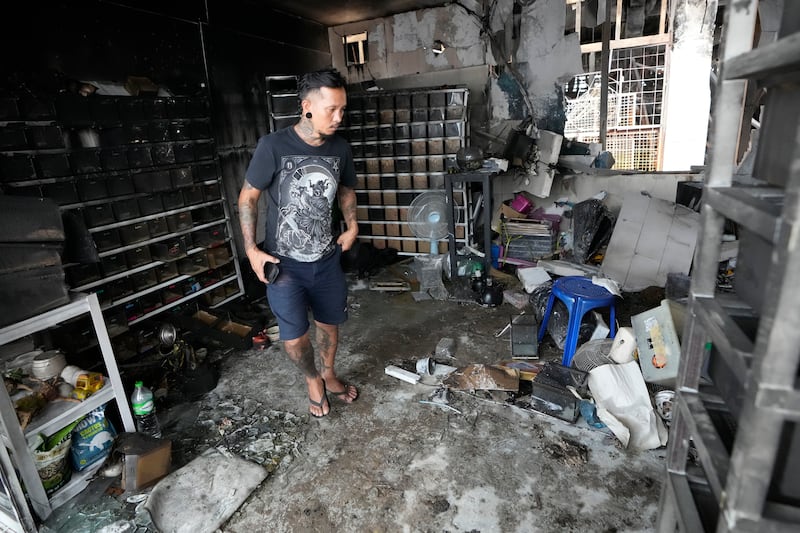 The owner of a pet shop surveys damage after a fire at Chatuchak Weekend Market, one of the most famous markets in Bangkok, Thailand (Sakchai Lalit/AP)