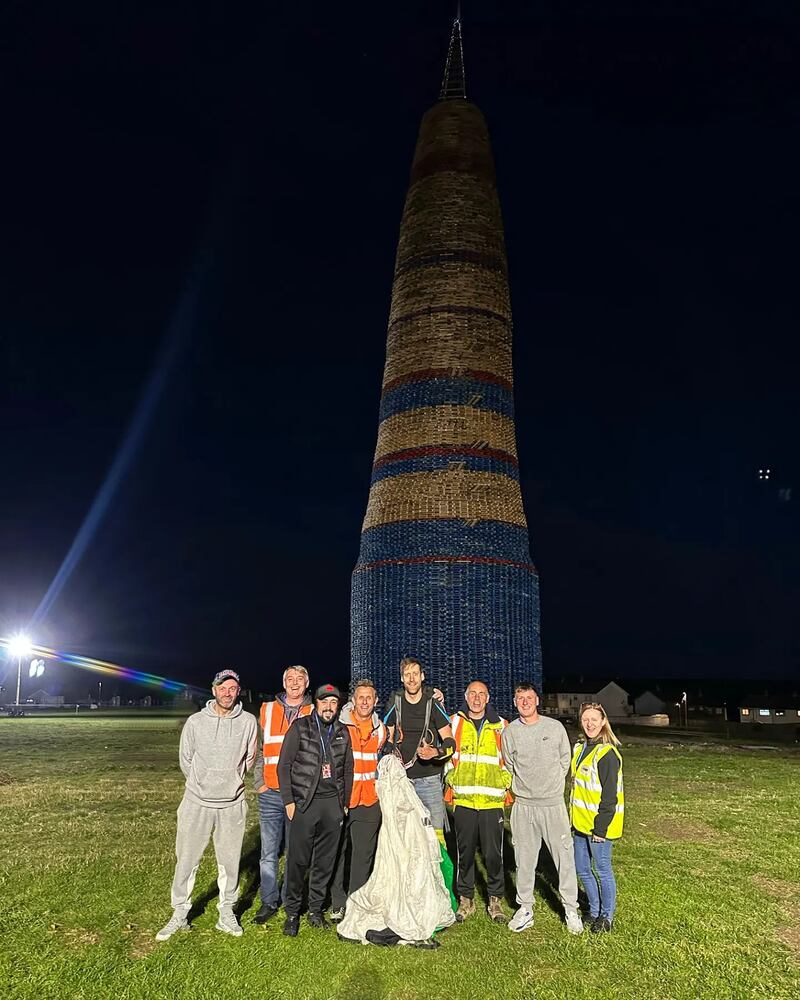 Base jumper Stephen Maginnis, centre, posed for photos after leaping off the Craigyhill bonfire. PICTURE: STEPHEN MAGINNIS