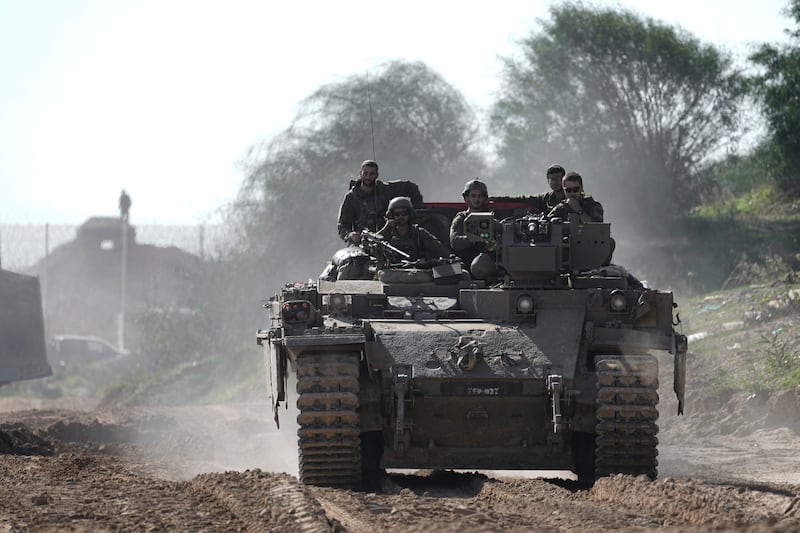 Israeli troops crossing into Israel from Gaza on Saturday (Tsafrir Abayov/AP)