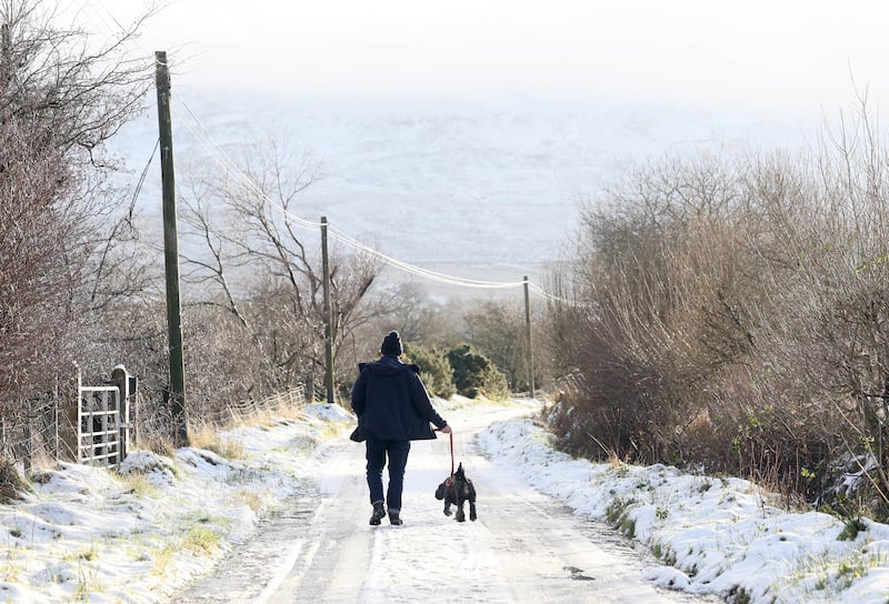 PACEMAKER, BELFAST, 3/1/2025: A man walks his dog along a snow covered lane in the Sperrin Mountains today. More snow is forecast for the weekend.
PICTURE BY STEPHEN DAVISON