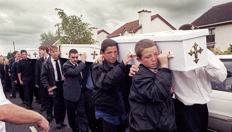 Friends and relatives carry the three coffins of the Quinn brothers 