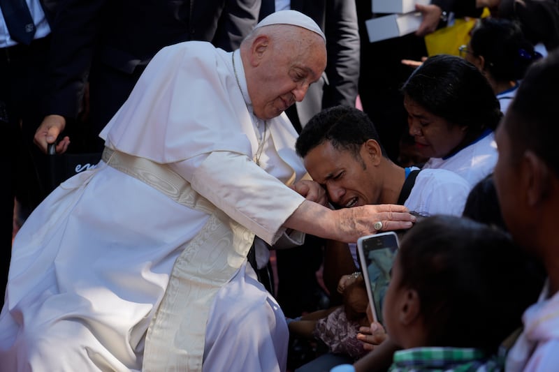 Pope Francis consoles a disabled man during a visit to the Irmas Alma school (Gregorio Borgia/AP)