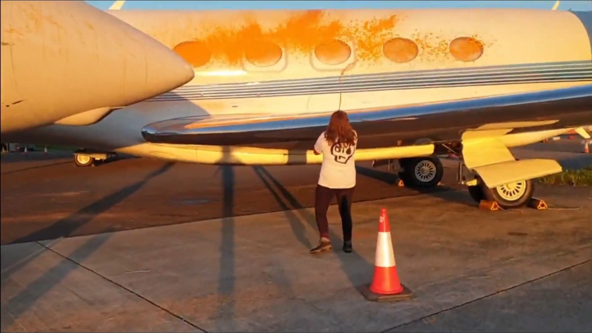 Screen grab taken from handout video of Just Stop Oil protesters spraying orange paint over parked private jets at London Stansted Airport in Essex