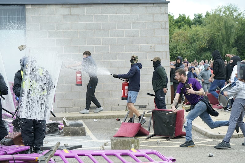 Levi Fishlock (right) was a prominent figure in the disorder outside the hotel and was wearing a distinctive purple England football shirt