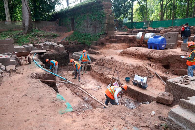 Archaeologists working at unearthing a centuries-old sandstone statue at Angkor Thom in Cambodia (Phouk Chea/Apsaras National Authority via AP)