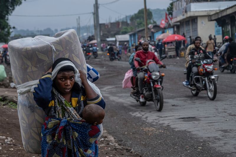 People displaced by the fighting with M23 rebels make their way to the centre of Goma (Moses Sawasawa/AP)