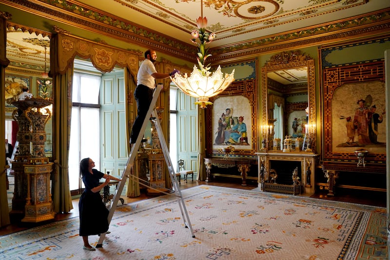 Final preparations are made in the Centre Room, where members of Royal Collection Trust staff tend to a chandelier, in the East Wing of Buckingham Palace which is being opened to visitors for the first time this summer