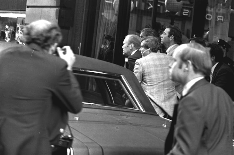 President Gerald Ford ducks behind his limousine and is hustled into the vehicle after a shot was fired as he left the St Francis Hotel in San Francisco in September 1975 (AP)