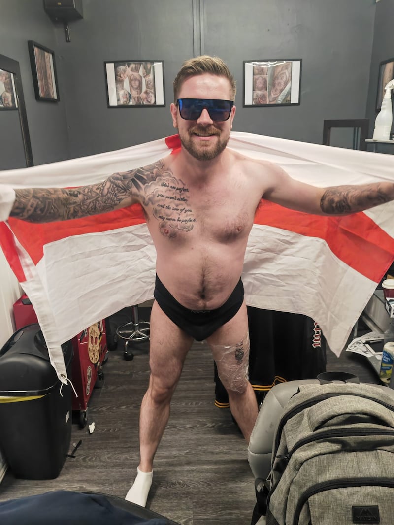 Jack Wilkinson, Dan Thomas’s friend and tattoo shop owner, pictured the moment Mr Thomas held the England flag after his tattoo (Jack Wilkinson)