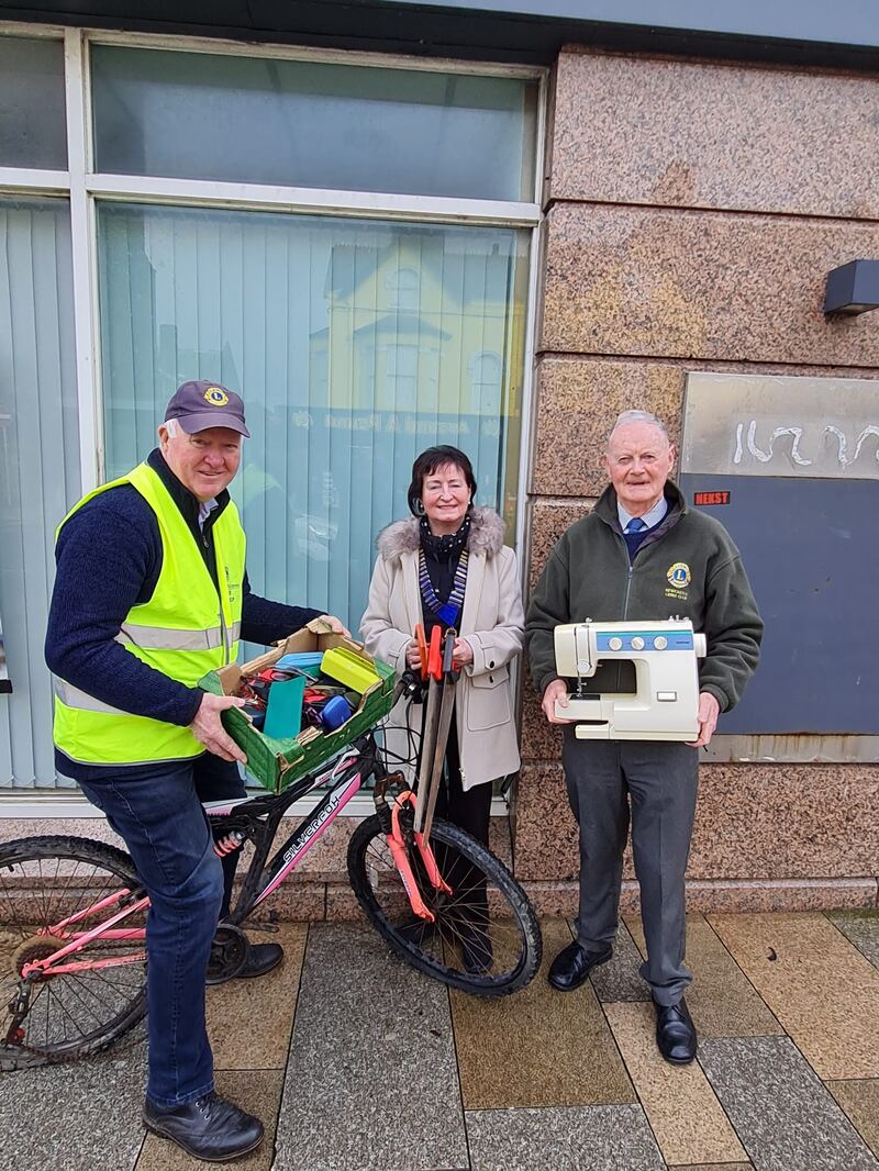 Members of Newcastle Lions club outside the  AIB Bank  Main  Street Newcastle which is  drop off point for their  recycling collection on  Saturday 23rd March 2024.  Dan O’Reilly on a donate bike with a box of glasses complete with cases, President Liz Murphy with tools and Tom Hughes holds a sewing machine sent in this week