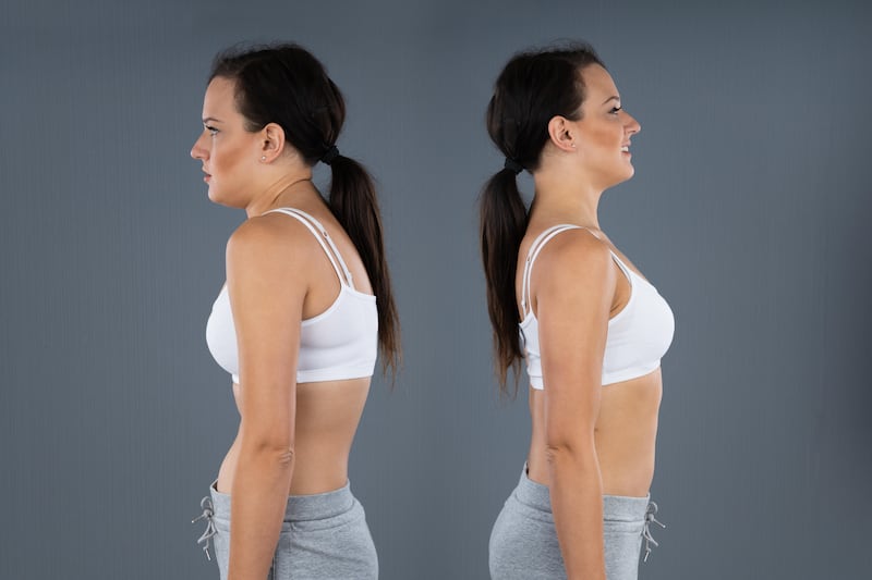 This is a photo of a woman hunching over and standing straight against a grey background