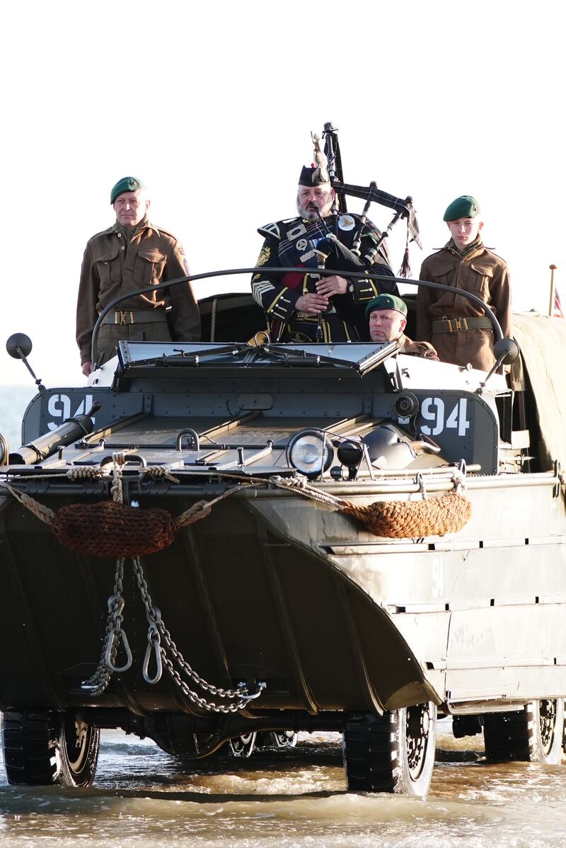 A military piper comes on to shore on Gold Beach in Arromanches