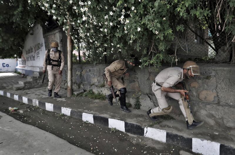 Members of the security forces take cover during clashes with stone pelters in Srinagar, Kashmir, 2017. Picture by Cathal McNaughton